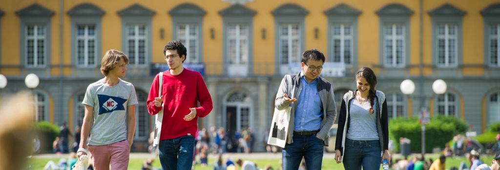 Studierende im Hofgarten vor dem Hauptgebäude der Universität Bonn