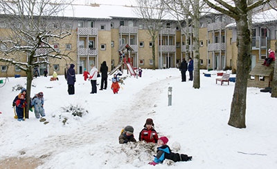 Auf dem Spielplatz im Innenhof des Kieler Studentendorfs an der Kita Olshausenstraße spielen Kinder im Schnee