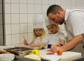 Vorschau: Ein Koch und ein Kind in der Küche.