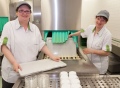 Vorschau: Zwei Mitarbeiterinnen entnehmen Tabletts vom Spülmaschinenband